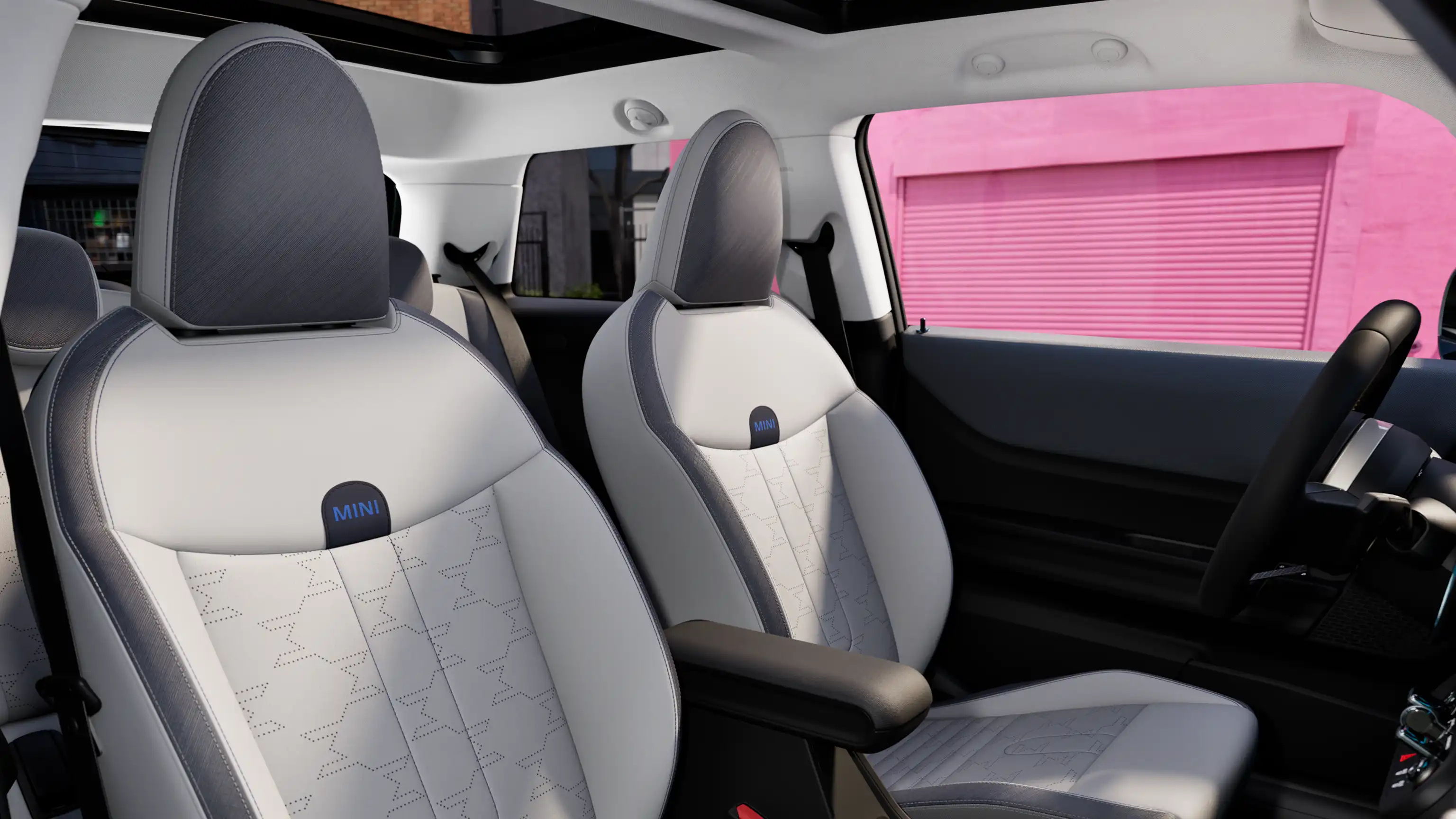 Binnenaanzicht van de MINI Cooper toont het dashboard, het stuurwiel, het ronde display, het glazen panoramadak en de achterkant van de voorstoelen.
